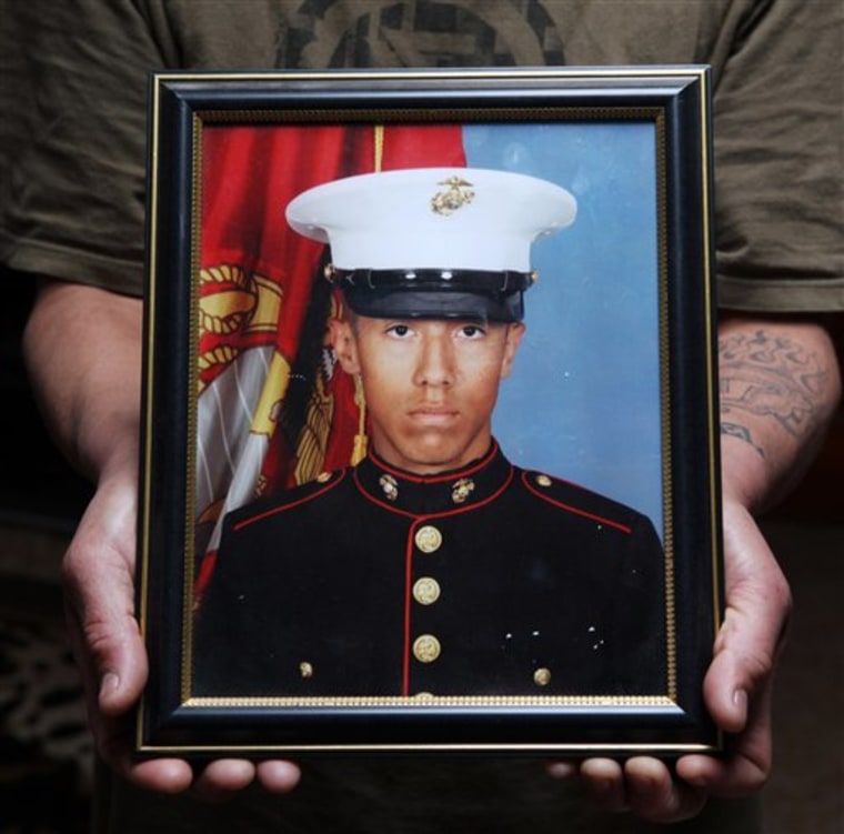 A relative holds a government military photo of Itzcoatl Ocampo, a former Marine who saw combat in Iraq, in Yorba Linda, Calif., Sunday. Ocampo is accused in a series of killings of homeless men in Orange County.